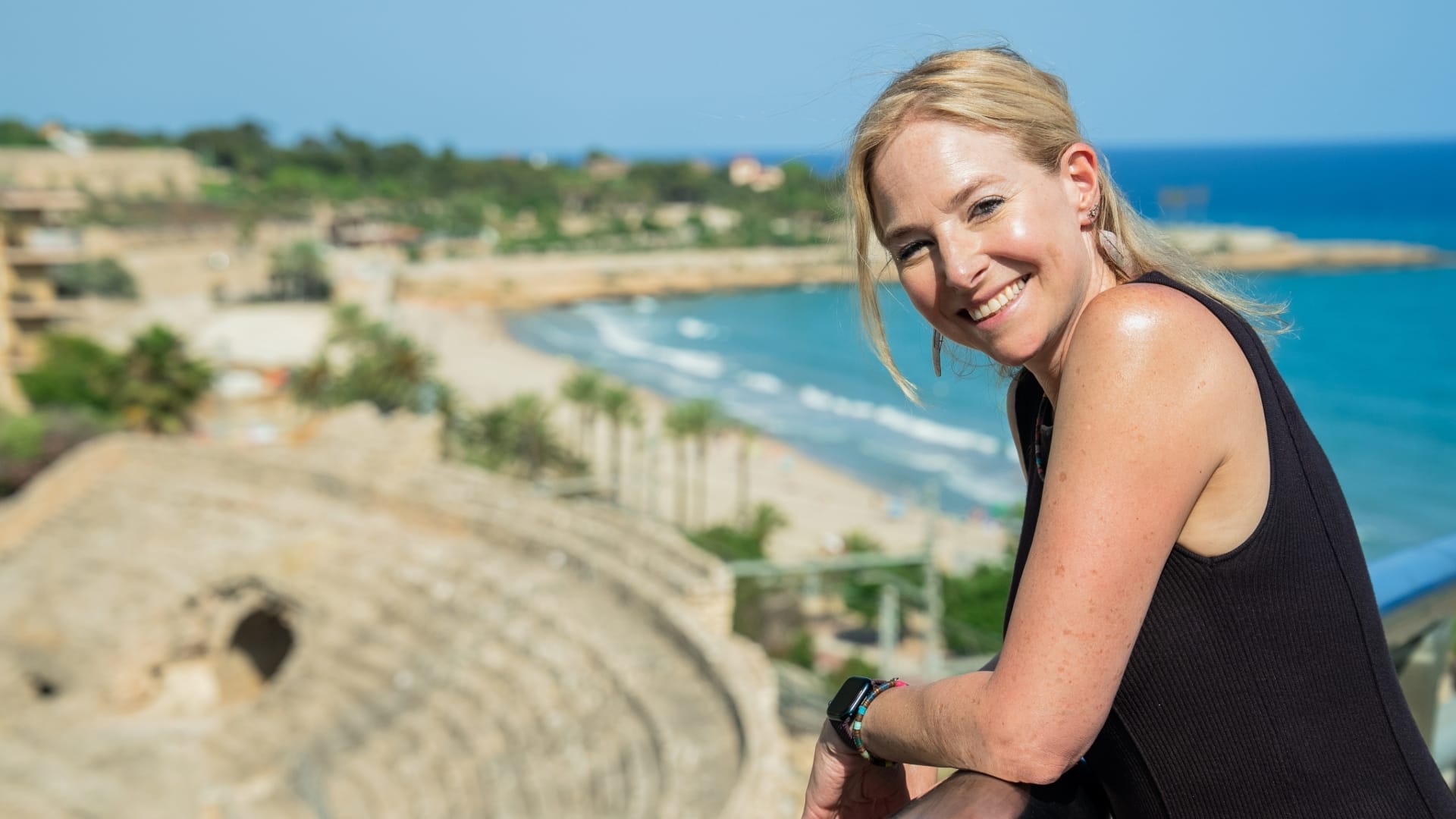 Alice Roberts smiling at camera with Roman Amphitheatre in the background