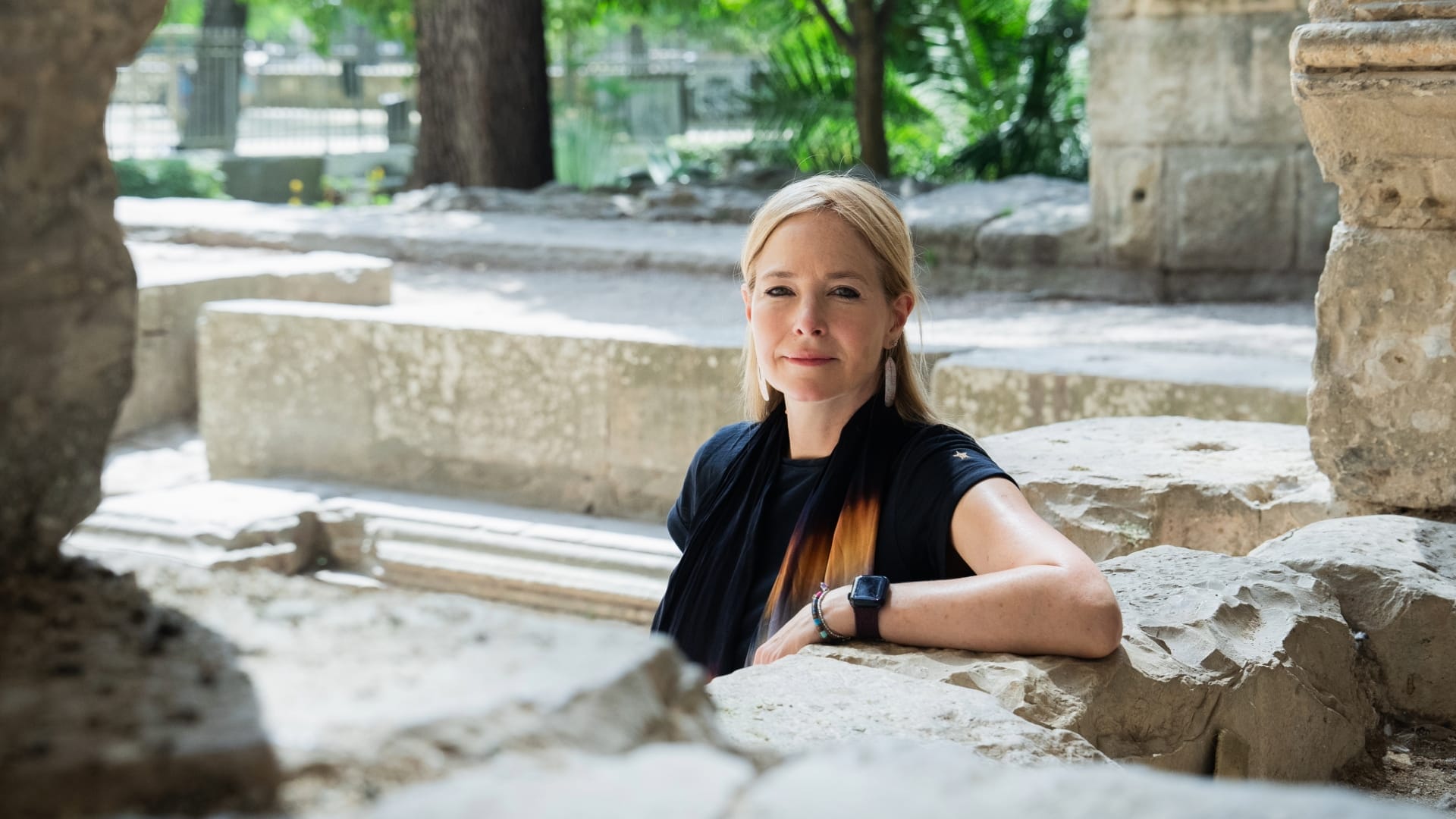 Alice Roberts sat looking to camera in a Roman Amphitheatre