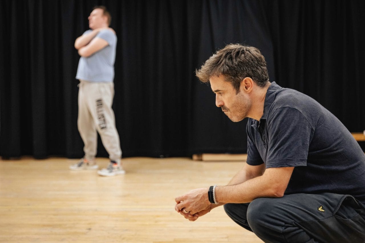 Joe McFadden as Andy Dufresne (and Sean Kingsley as Bogs Diamond, Background) in rehearsals for The Shawshank Redemption - photo by Mark Senior